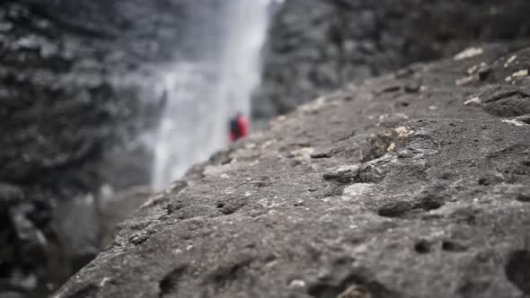 Man On Rocks Under Fossa Waterfall From Cliff