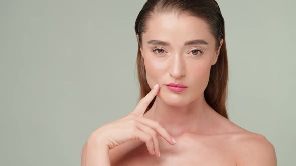 Beautiful Young Woman with Clean Fresh Skin Standing Over Light Grey Background