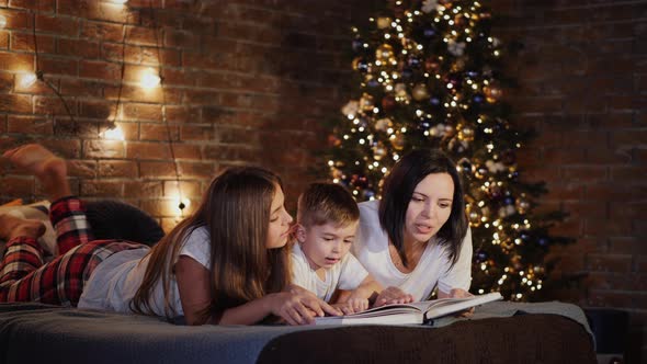 Mom Reads a Book To Children in the Bedroom