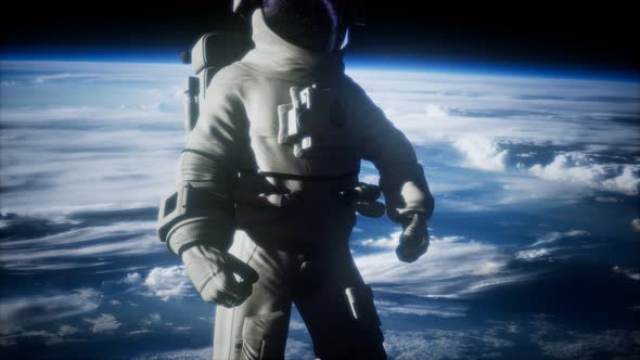 Astronaut in Outer Space Against the Backdrop of the Planet Earth alt