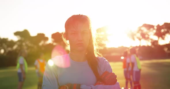 Female soccer player standing with arms crossed on soccer field. 4k