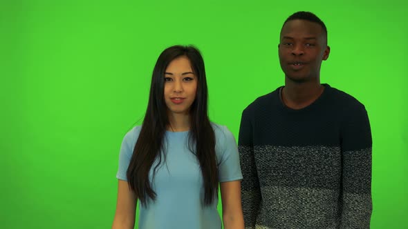 A Young Asian Woman and a Young Black Man Protest To the Camera - Green Screen Studio
