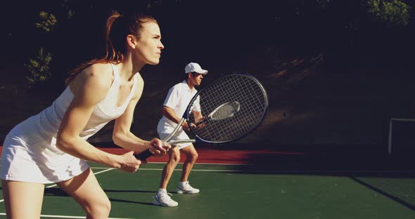 Woman and man playing tennis on a sunny day