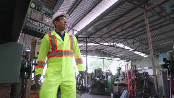 Group of Factory Workers Using Machine Equipment in Factory Workshop