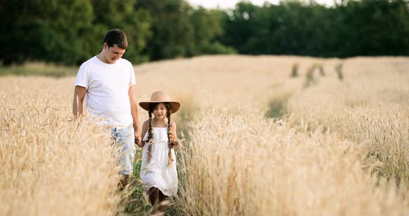 A Little Girl Walking on a Wheat Field with Her Dad Slow Motion