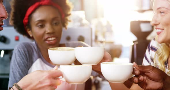 Group of happy friends holding cup of coffee