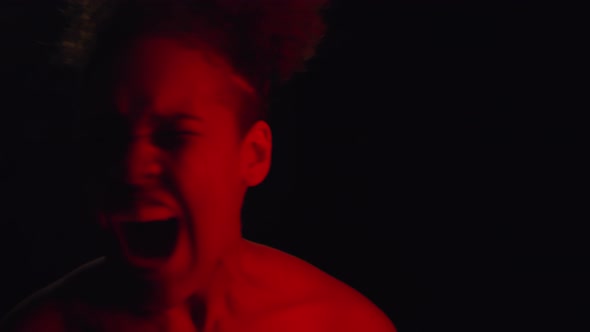 Young Woman Screaming in Red Lighting