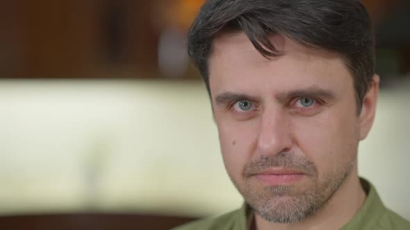 Dissatisfied Caucasian Man Looking at Camera with Angry Facial Expression Posing Indoors on the