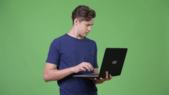 Young Handsome Teenage Boy Using Laptop