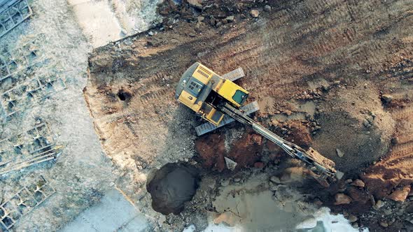 Soil Is Getting Extracted From Underground By the Digging Vehicle. Heavy Industrial Equipment