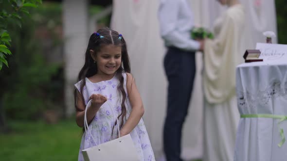 Medium Shot of Cheerful Beautiful Middle Eastern Girl Scattering Petals on Marriage Ceremony with