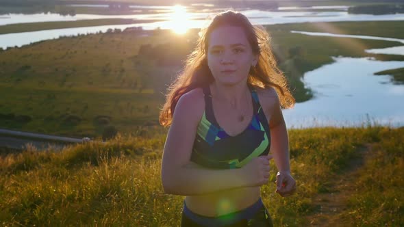 Young Woman Jogging on the Field on Sunset