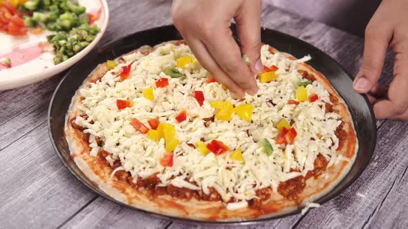 Young Women Putting Cheese on Pizza