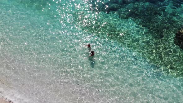 Shooting From Drone of Tourists Swimming in Clear Water Off the Coast of Suluada Island and a Sunny