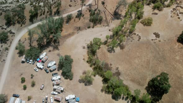 Aerial view of caravan, Santa Margarita. Drone flies forward over dry landscape, United States.