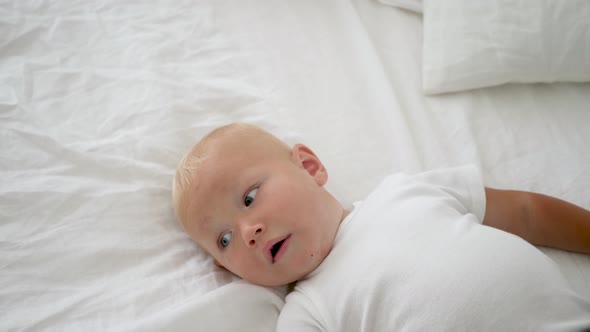 Boy with Blue Eyes in a White T-shirt and Blue Shorts