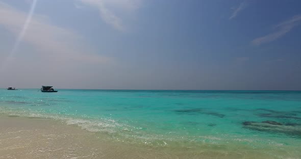 Tropical above tourism shot of a sunshine white sandy paradise beach and turquoise sea background in