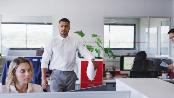 Professional businessman giving document paper to his colleague in modern office in slow motion