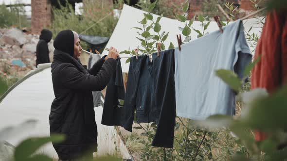 Woman Hanging Up Laundry at Refugee Camp