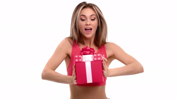 Funny Woman Playing Festive Red Gift Box with Bow Celebrating Holiday