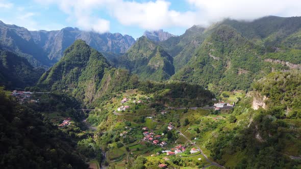 Aerial drone view of a mountain village.  Rural holidays. Clouds with sun. Travel the world.