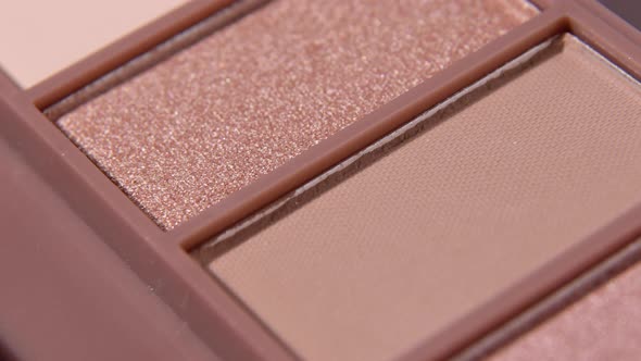 Eyeshadow palette natural shades for makeup close up. Camera moving bottom to up