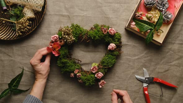 Hands Decorates Floral Wreath for Valentines Day