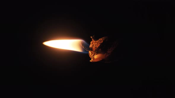 Vertical Footage. A Single Candle Lit on Black Background. Candle Flame in Dark