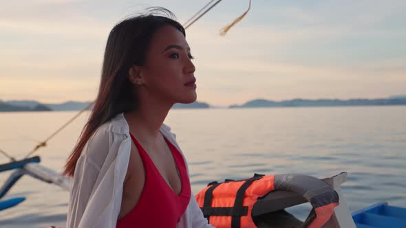 Woman Relaxing On Outrigger Boat Looking Away