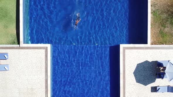 Aerial top view of Man in swimming pool from above