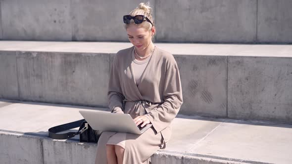 Female Freelancer Using Laptop on Street Stairs