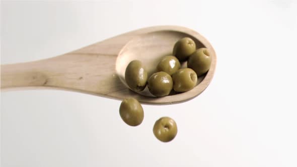 Olives falling in super slow motion from the spoon