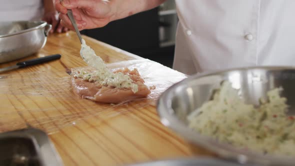 Caucasian female chef teaching diverse group preparing dishes and smiling