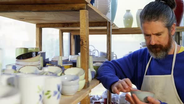 Male potter examining a earthenware bowl