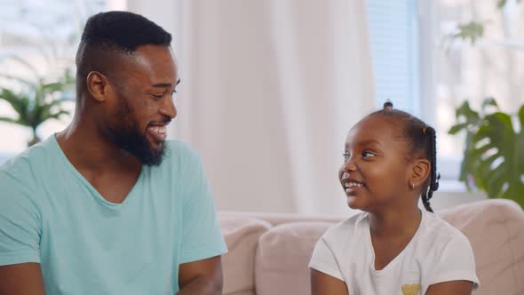 Africanamerican Daughter Hugging Father with Love and Tenderness at Home