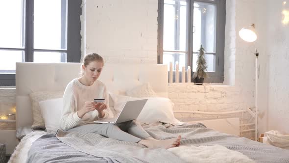 Online Shopping By Young Girl Sitting in Bed Using Laptop