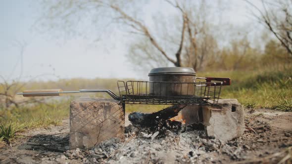 Cooking Food on the Campfire Near the River Slow Motion Shot