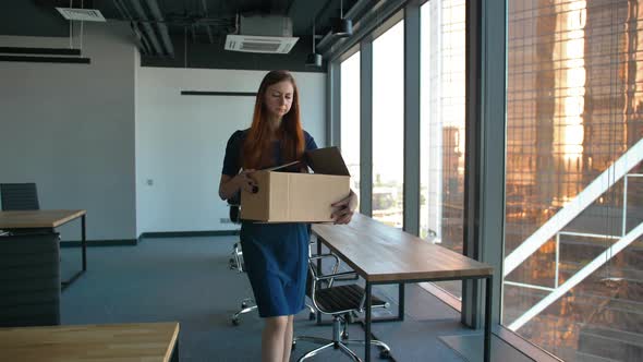 Sad Female Employee Leaving the Office After Being Fired