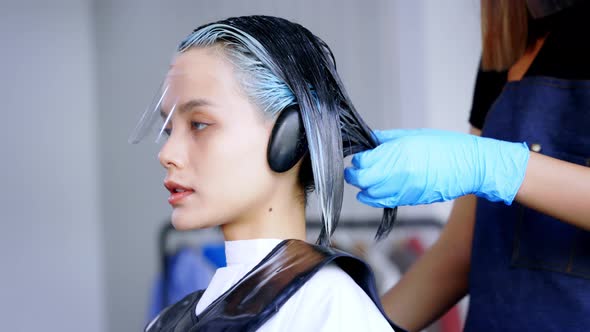 Hairdresser Colouring Hair of Woman