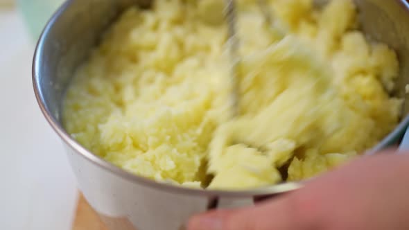 Female Hands with a Pusher Knead Boiled Potatoes Mashed Potatoes