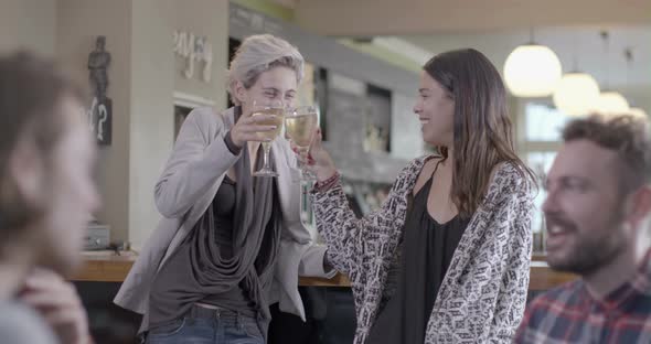 Women enjoying wine and talking in pub