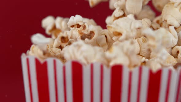 Falling Popcorn in Super Slow Motion on Red Background.