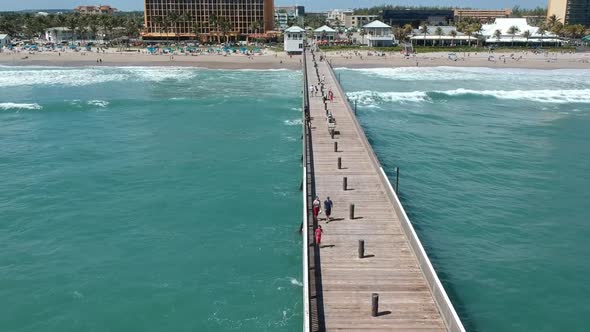 Flying near a pier following the wave braking on the shoreline