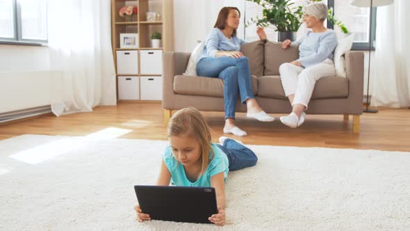 Adults Talking and Girl Using Tablet Pc at Home 