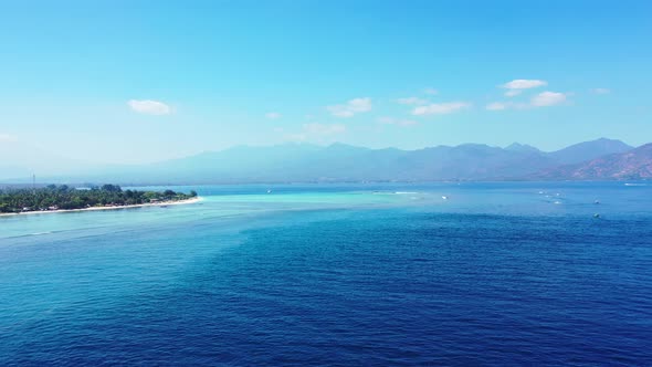 Wide angle above clean view of a white paradise beach and blue water background in colourful 4K
