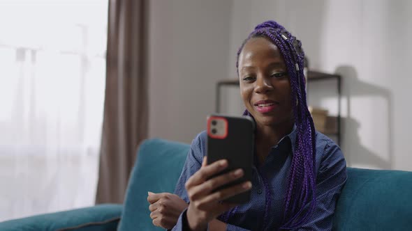 Young Afroamerican Woman is Communicating with Friends or Family By Video Chat in Modern Smartphone
