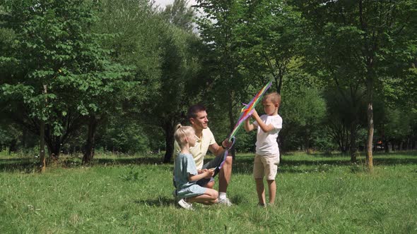 Family Day, Father with Kids Sets Up a Kite, Outdoor Activities with Children.