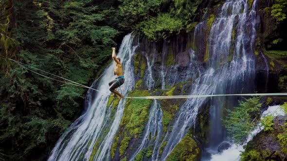 Fit Man High-lining Over A Waterfall