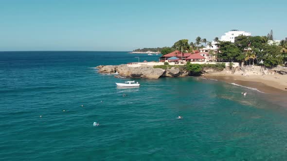 Flight over the ocean coast rifs and hotels and people on vacation