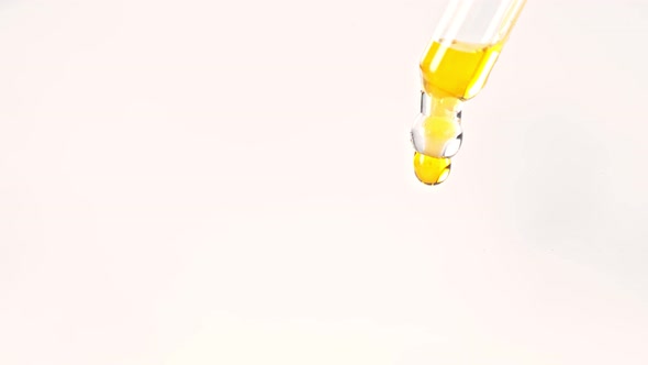 Super Slow Motion Shot of Oil Drop From Dropper Isolated on White Background at 1000Fps